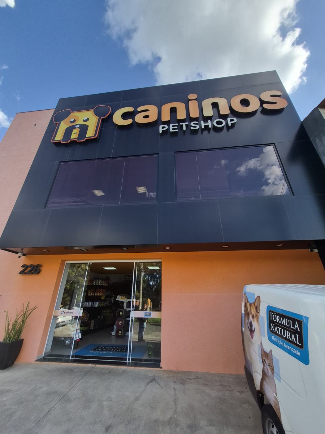 Fachada da Caninos Pet Shop com letreiro laranja
